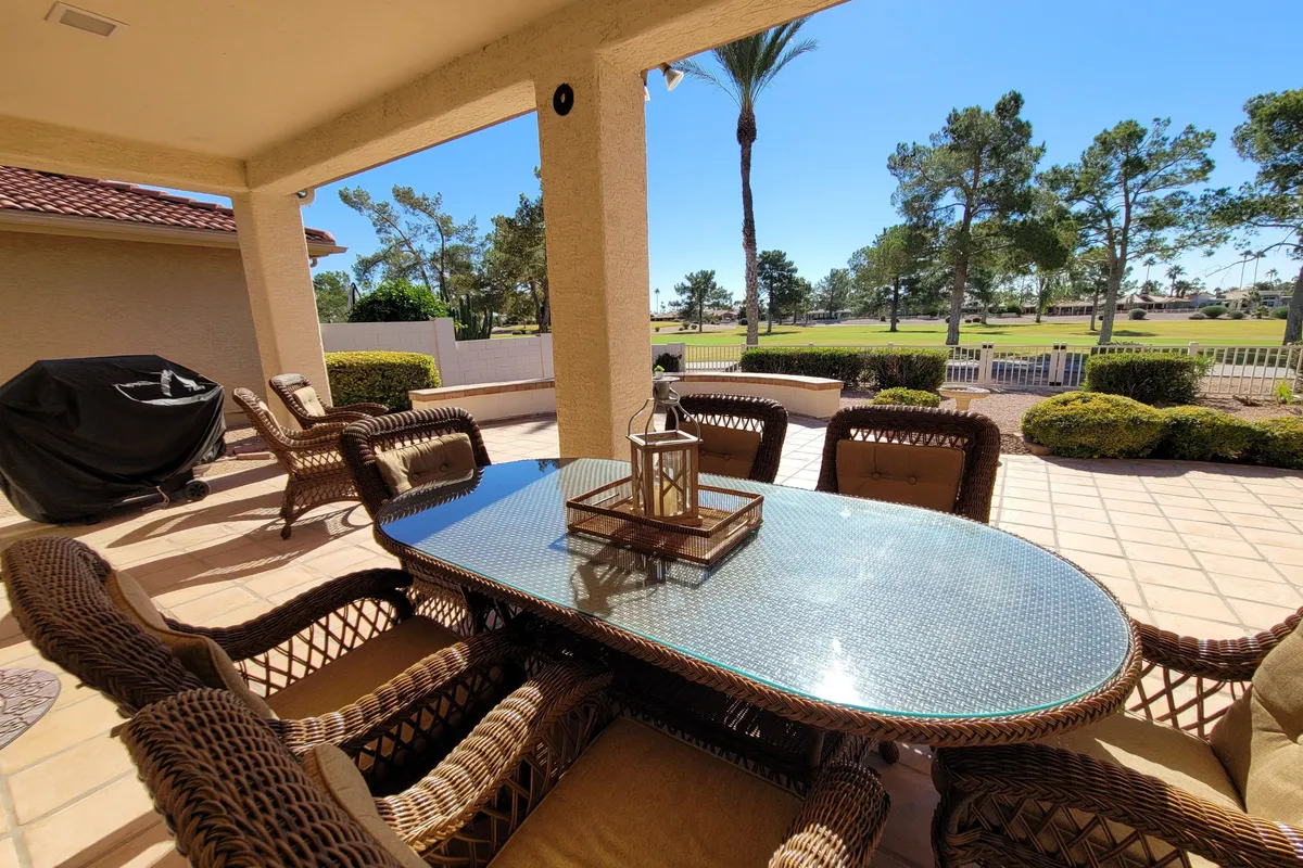 An inviting outdoor dining area with a table and lantern set against a scenic landscape view, ideal for al fresco dining, relaxation, and social gatherings. The backdrop features sunset tones and open sky, evoking a sense of community and connection.